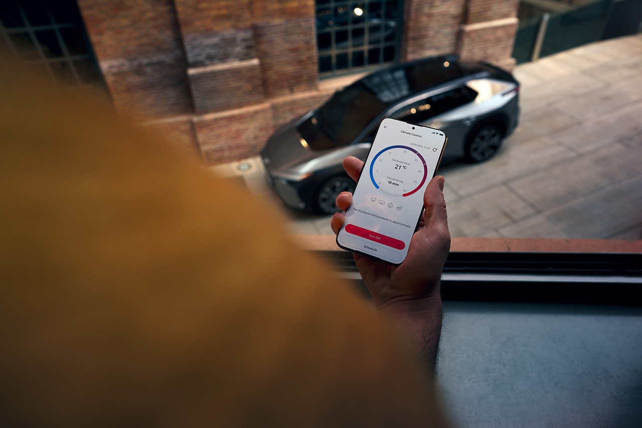 Homme tenant son téléphone Toyota MyT