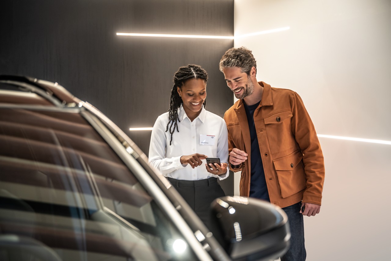 Visuel d'un client et d'un vendeur Toyota au sujet de la recharge électrique